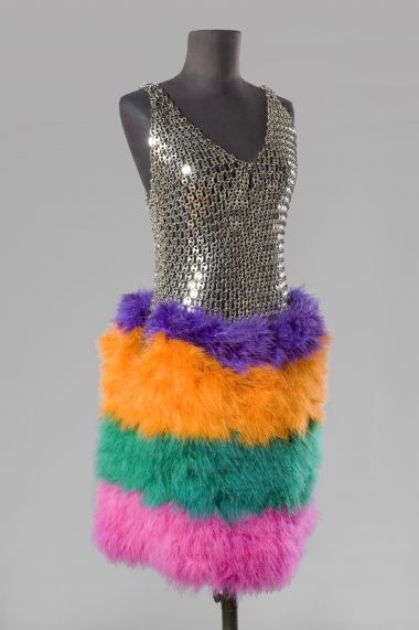 <p>Robe sans manche compos&eacute;e de " grains de caf&eacute;" m&eacute;talliques argent&eacute;s et d'une jupe en plumes de cygne lustr&eacute;e bayad&egrave;re, 1980, estimation : 2000&euro; - 3000&euro;.</p>